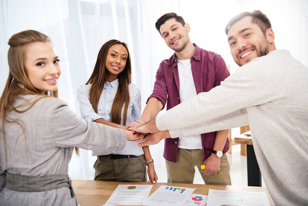 Multikulturelle Gruppe von Marketing-Managern, die im Amt die Hände zusammenhalten, Teamwork-Konzept - Foto, Bild