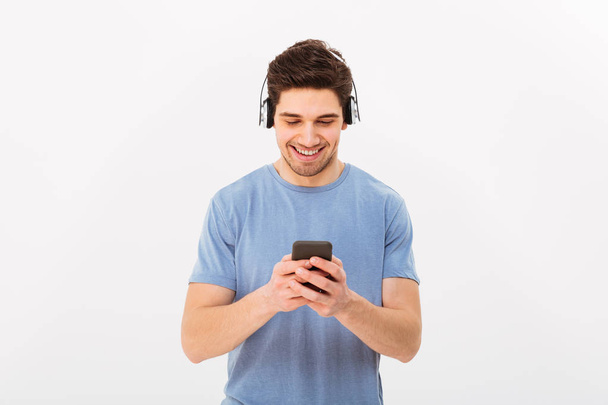 Attractive man with short dark hair listening to music via wirel - Foto, Bild