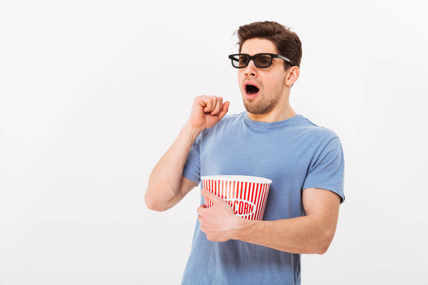 Shocked man in t-shirt and 3d glasses eating popcorn - Photo, Image