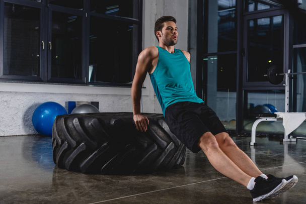 sportsman doing push ups on tire in gym - Φωτογραφία, εικόνα