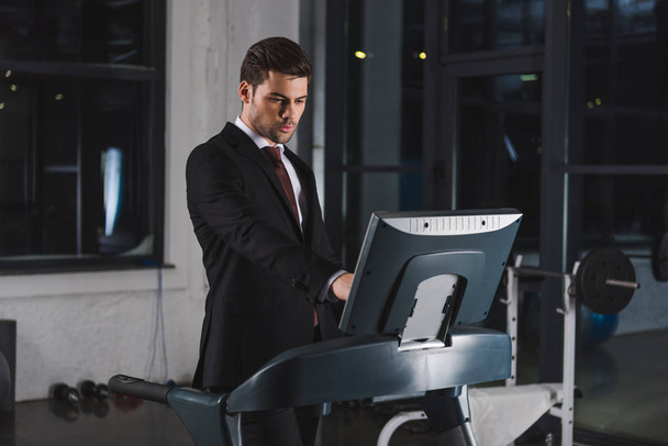 handsome businessman in suit training on treadmill in sports center  - Photo, Image