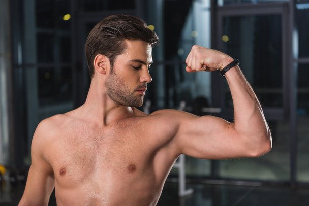shirtless handsome sportsman showing muscles in gym - Photo, image
