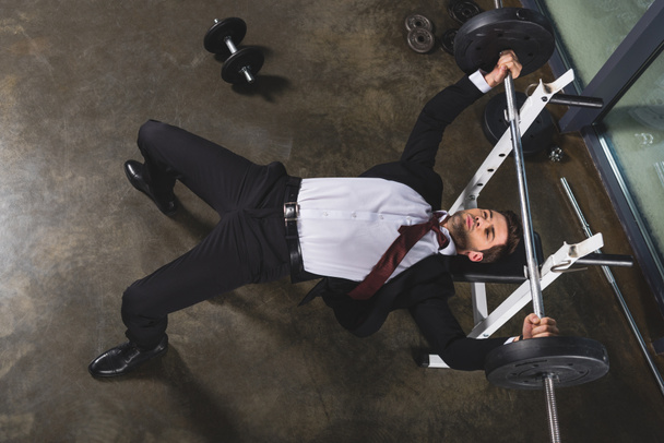 businessman in suit training with barbell in sports center - Fotografie, Obrázek