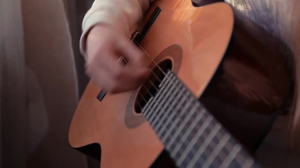 Молодая девушка играет на гитаре крупным планом
 - Кадры, видео