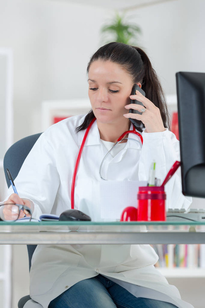 portrait of young female doctor on phone at office - Foto, Imagem