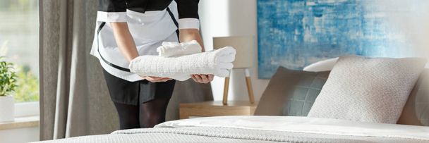 Panorama of housemaid putting towels - Foto, afbeelding