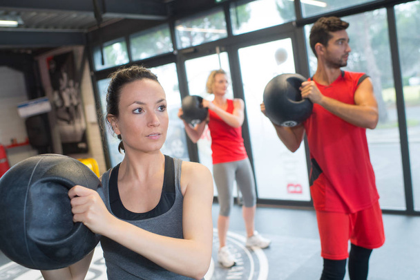 People in fitness class holding round prop - Foto, Bild