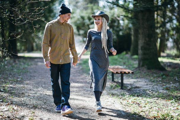 Cheerful couple walking at park alley and holding hands - Fotoğraf, Görsel