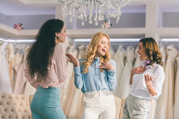 Young women having fun in wedding fashion shop - 写真・画像
