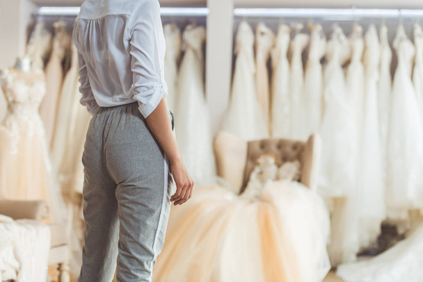 Cropped view of woman choosing dress in wedding atelier - Fotografie, Obrázek