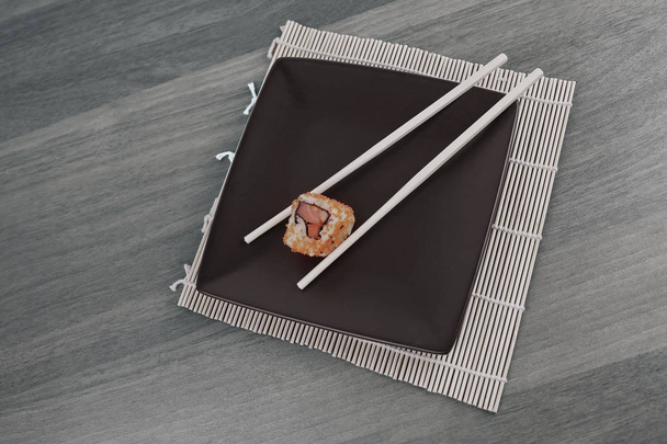 Nahaufnahme von Sushi und Essstäbchen auf einem Holztisch - Foto, Bild