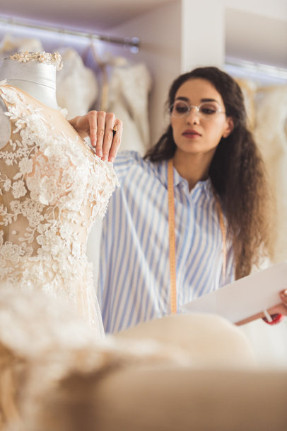 Krejčí, připojení dekorativní detaily se oblékat v svatební salon - Fotografie, Obrázek