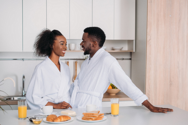 African american couple having breakfast in kitchen - Fotó, kép