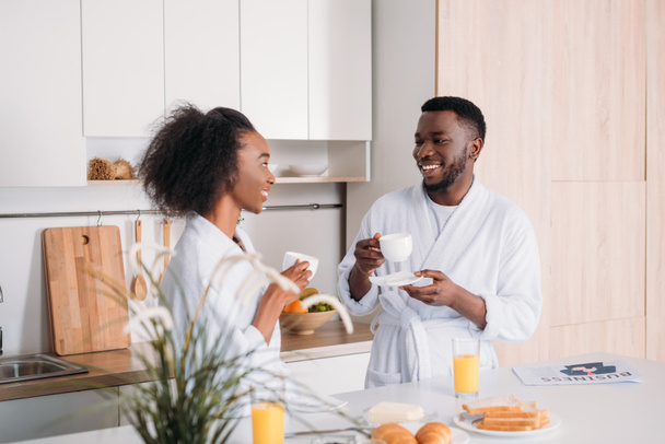Jóvenes afroamericanos pareja bebiendo café en la cocina
 - Foto, Imagen