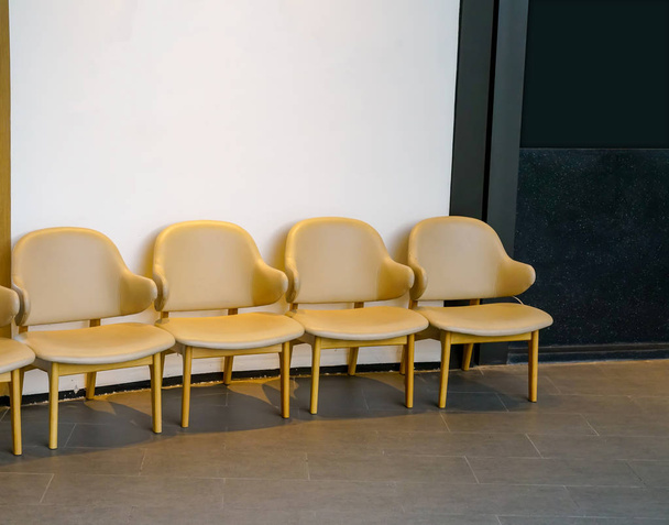Wiersz lekkie brązowe krzesła w korytarzu. Alignme krzesła skórzane - Zdjęcie, obraz