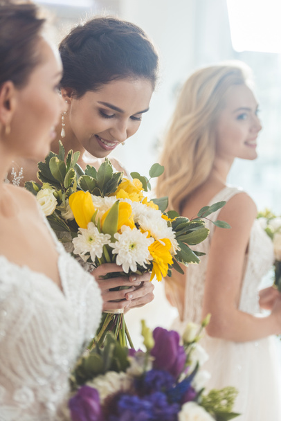 Mladí nevěsty drží něžně květy kytice Svatební salon - Fotografie, Obrázek