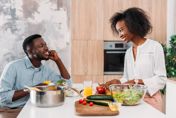 African american para przy stole z warzywa, sałatki i makarony w garnku  - Zdjęcie, obraz