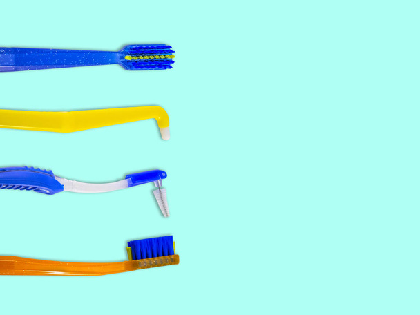 Brosses à dents spéciales pour le soin des accolades (systèmes de support), en rangée, isolées sur un fond bleu clair, vue du dessus, avec espace pour le texte
 - Photo, image