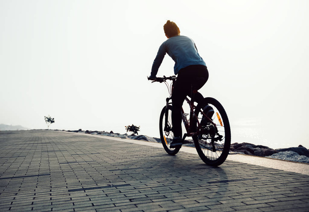 cyclist riding mountain bike on the coast - Foto, imagen