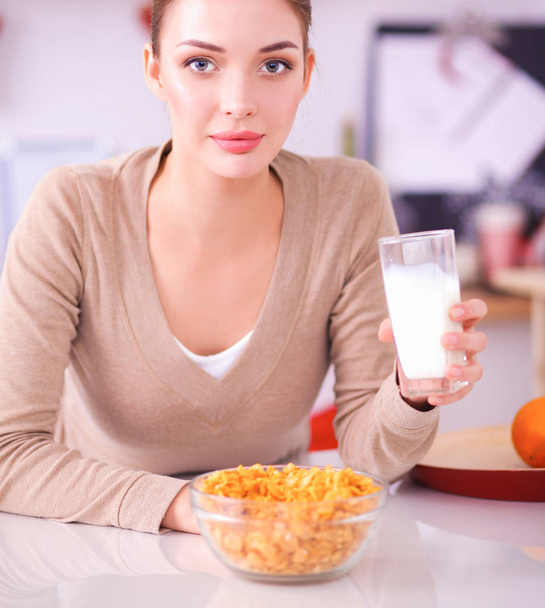 Smiling attractive woman having breakfast in kitchen interior - Zdjęcie, obraz