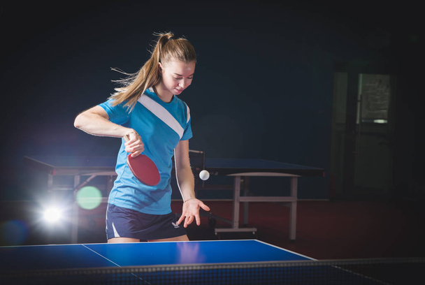 Portrait Of Young Woman Playing Tennis On Black Background with  - 写真・画像