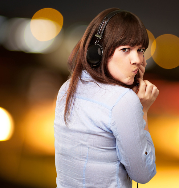 Женщина с наушниками и надутыми губами
 - Фото, изображение