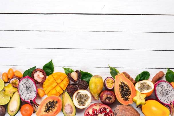 Tropical fruits, papaya, Dragon Fruit, rambutan, tamarind, cactus fruit, avocado, granadilla, carambola, kumquat, mango, mangosteen, passionfruit, coconut. On a wooden background. - Photo, image