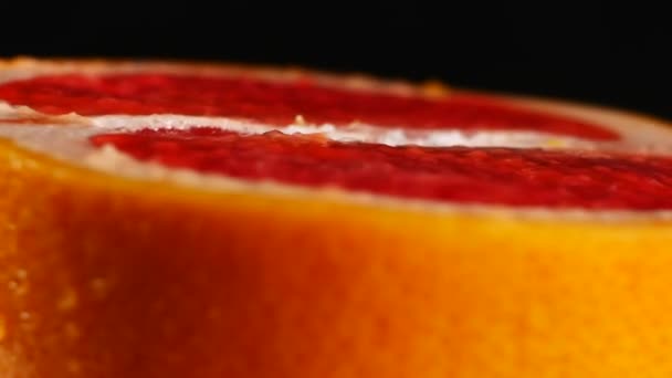 Half of grapefruit, rotating on a black background - Video, Çekim