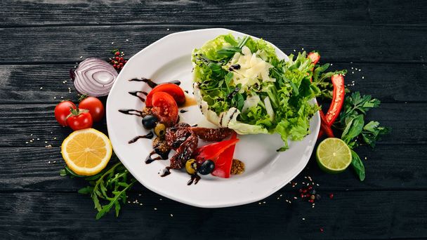 Salad with tomatoes, arugula and smoked tomatoes. On a wooden background. Top view. Copy space. - Фото, изображение