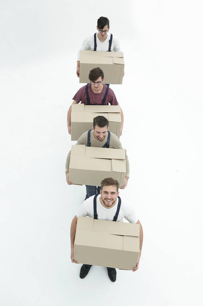 Young movers holding boxes standing in a row, isolated on white  - Fotoğraf, Görsel