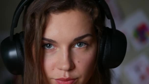 close-up of beautiful young woman listening to music on headphones - Кадры, видео