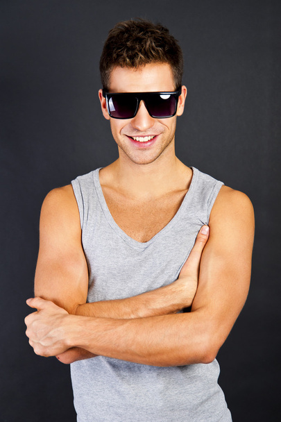 Handsome man in gray tanktop with smile and sunglasses - Photo, Image