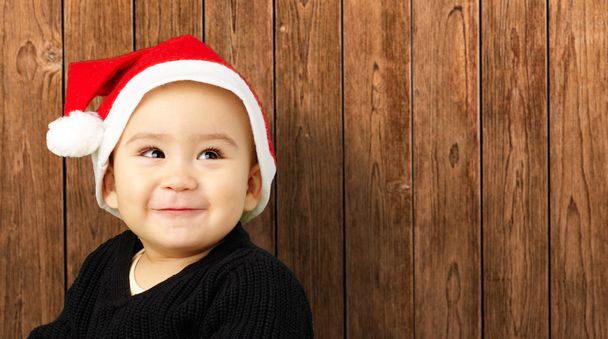 Kisfiú, mosolyog, és karácsonyi kalapban - Fotó, kép