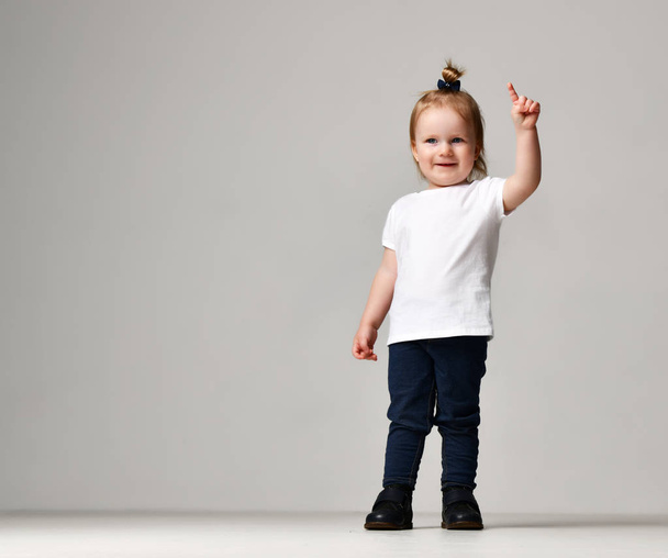 Peuter kind baby meisje kind opkomen in witte vrije tekst ruimte t-shirt wijzende vinger - Foto, afbeelding