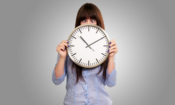 Woman Holding Clock With Squinted Eyes - Photo, Image