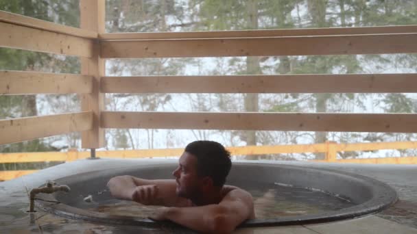 Un hombre se baña en la tina de hierro fundido con agua mineral y enciende el grifo con agua fría
. - Metraje, vídeo