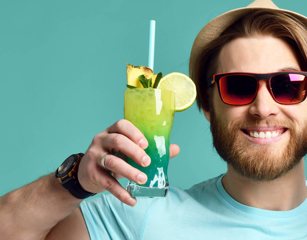 Young man in hat hold margarita cocktail drink juice happy smiling in red sunglasses - 写真・画像