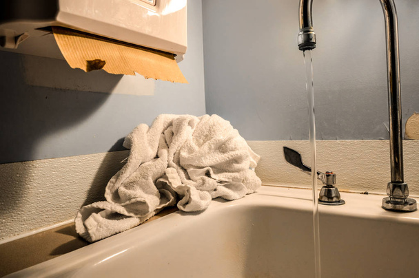 Vieille salle de bain propre de l'hôpital public avec serviette et distributeur de serviettes en papier
 - Photo, image