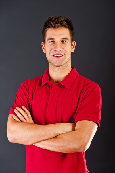 man op zwarte achtergrond met rode shirt - Foto, afbeelding