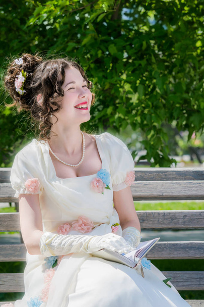 Молодая счастливая девушка в длинном белом платье невесты с улыбкой является Rea
 - Фото, изображение