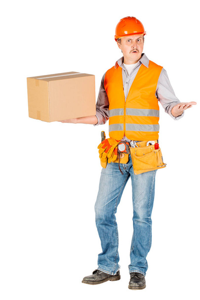 male builder or manual worker in helmet holding and moving  cardboard box on white background. repair, construction, building, people and maintenance concept - Photo, Image