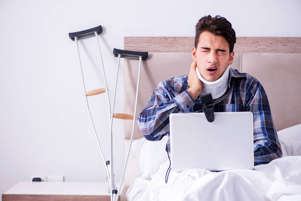 Homem ferido conversando online via webcam na cama em casa - Foto, Imagem