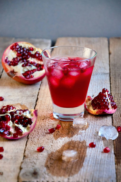 Cóctel de granada con hielo y fruta en mesa de madera. Refrescante bebida de verano suave o alcohólica
 - Foto, Imagen