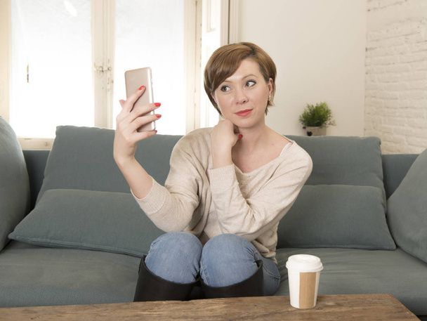 giovane attraente e felice donna capelli rossi seduto a casa divano c
 - Foto, immagini