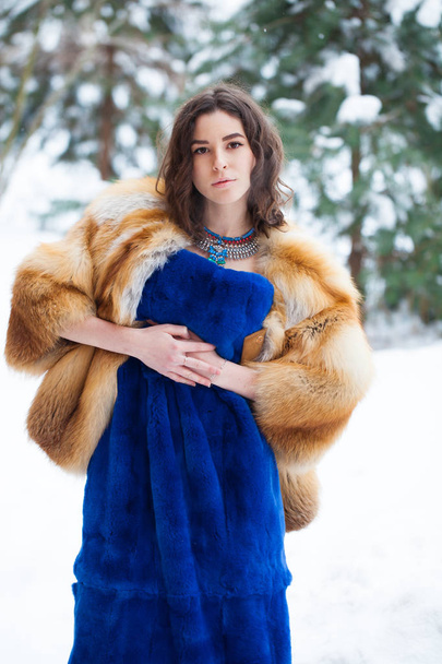 Nuori kaunis brunette nainen turkis takki poseeraa talvipuisto
 - Valokuva, kuva