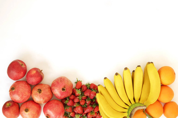 Плоская композиция с различными видами смешанных свежих органических фруктов и ягод на белом фоне столешницы, студийный свет, пространство для копирования, вид сверху
. - Фото, изображение