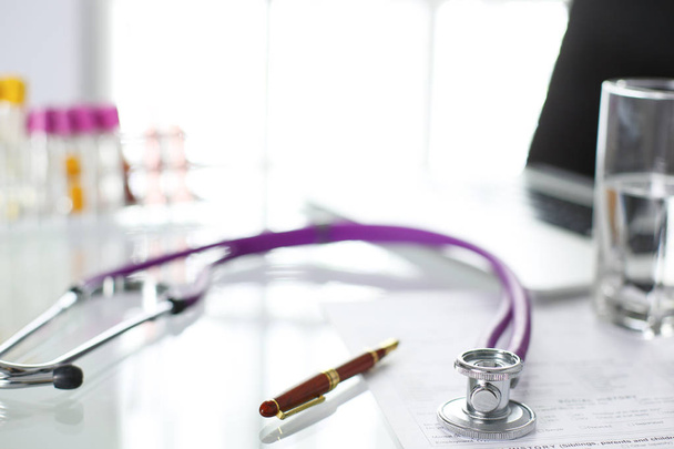 bir doktor ofisi ile bir stetoskop ön planda ve arka planda hapları bir şişeyle Resepsiyon closeup - Fotoğraf, Görsel