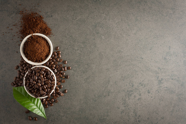 Grãos de café e pó moído com folha sobre fundo de pedra. Para
 - Foto, Imagem