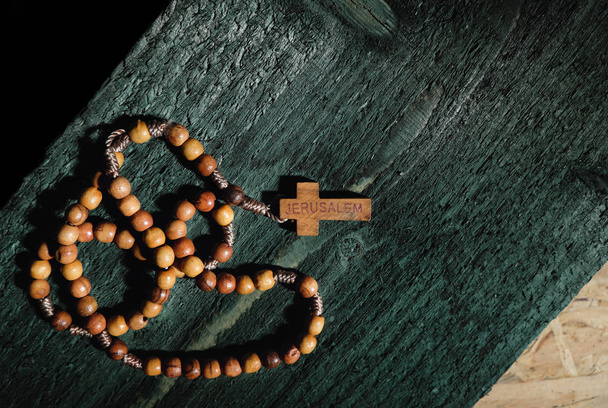 Rosario cattolico romano con perline di legno ed etichetta di Gerusalemme su croce
 - Foto, immagini