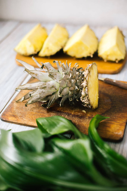 Sliced fresh pineapple on a wooden background in sunlight - Φωτογραφία, εικόνα